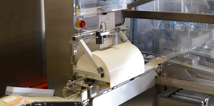 Transportband mit verpacktem Käse, der durch ein Lesegerät von Kaiser engineering läuft, das mit Industriekameras von SVS-Vistek ausgestattet ist.